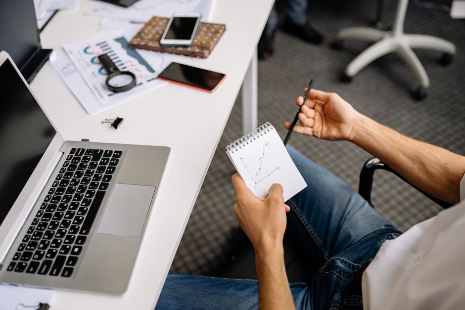 Empresário examinando um gráfico de linhas em um espaço de escritório moderno.