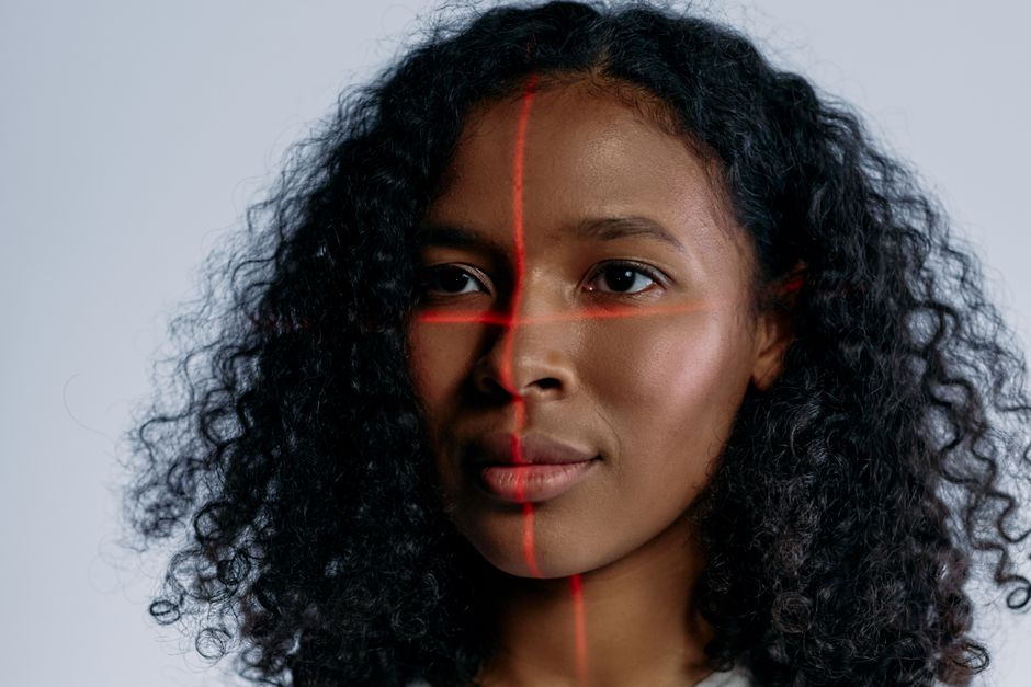 Um retrato futurista de uma mulher com linhas de escaneamento a laser no rosto, representando tecnologia avançada.